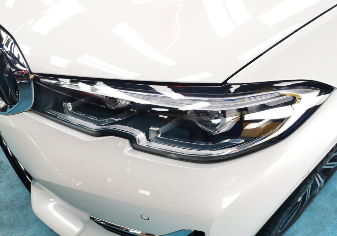 The 320i's coated paintwork holding clean reflections.