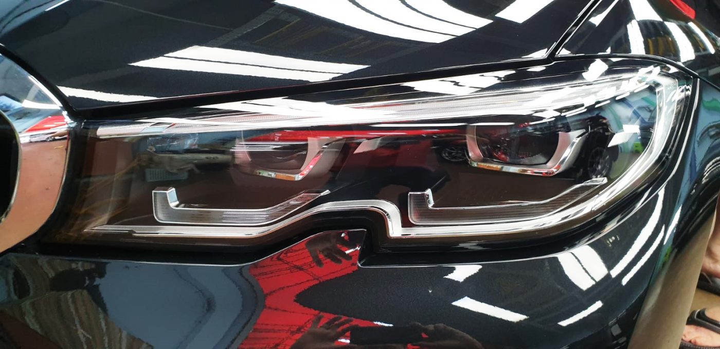 The 320i's coated paintwork showing clean reflections.