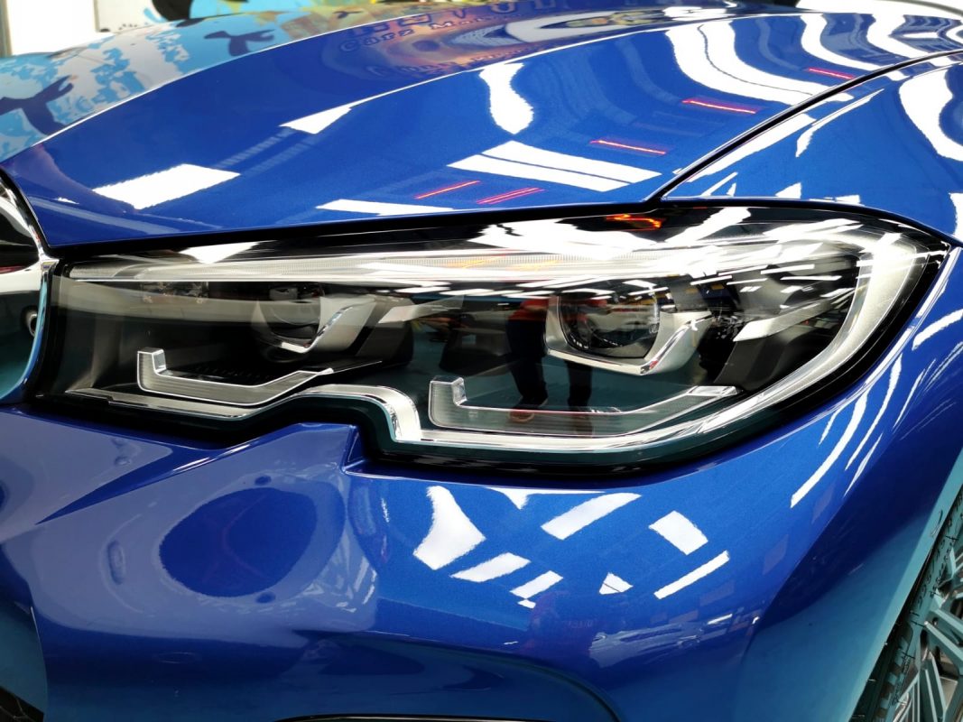 The 320i's coated paintwork showing clean reflections.