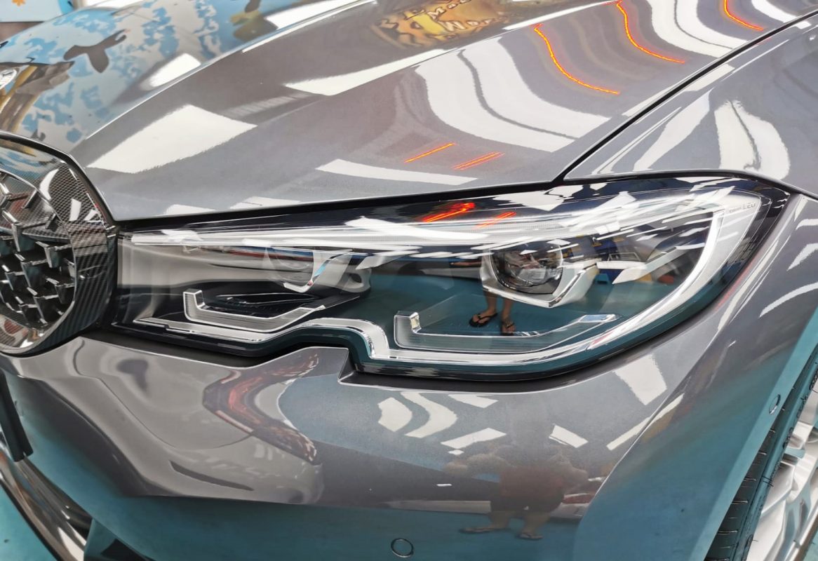 The 330i's coated paintwork holding clean reflections.