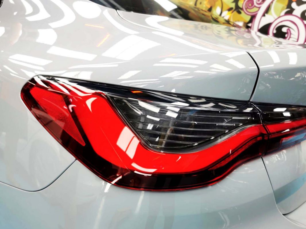 The coated bonnet of the BMW 4 Series under workshop lighting.