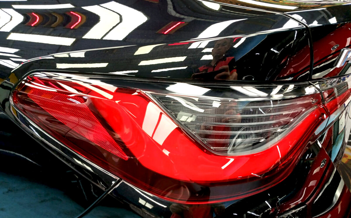 The coated bonnet of the BMW 4 Series under workshop lighting.