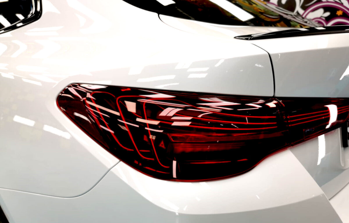 The coated bonnet of the BMW 4 Series under workshop lighting.