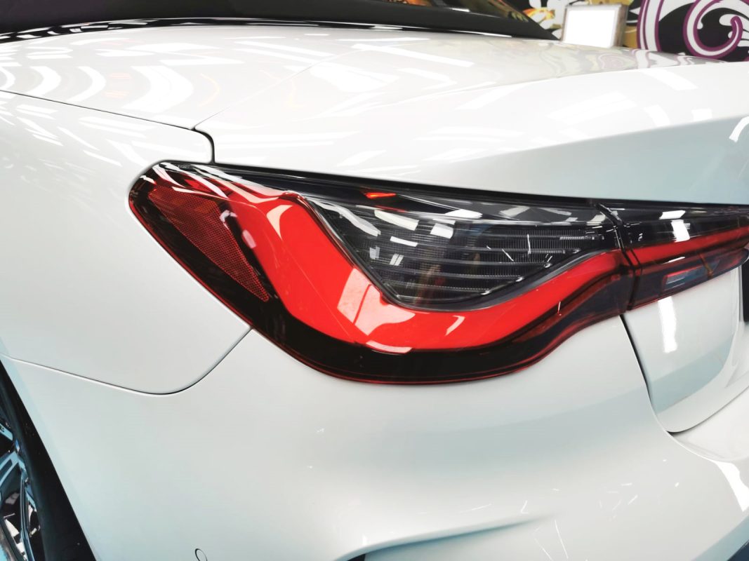 The coated bonnet of the BMW 4 Series under workshop lighting.