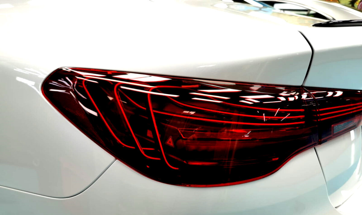 The coated bonnet of the BMW 4 Series under workshop lighting.
