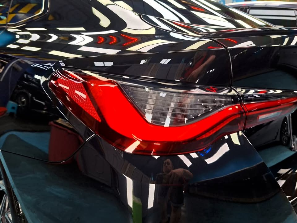 Close-up of the BMW 4 Series tail light against the black paint.