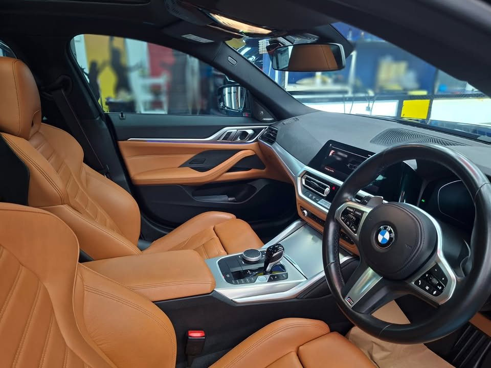 Interior of the BMW 4 Series with tan leather seats, steering wheel and dashboard.