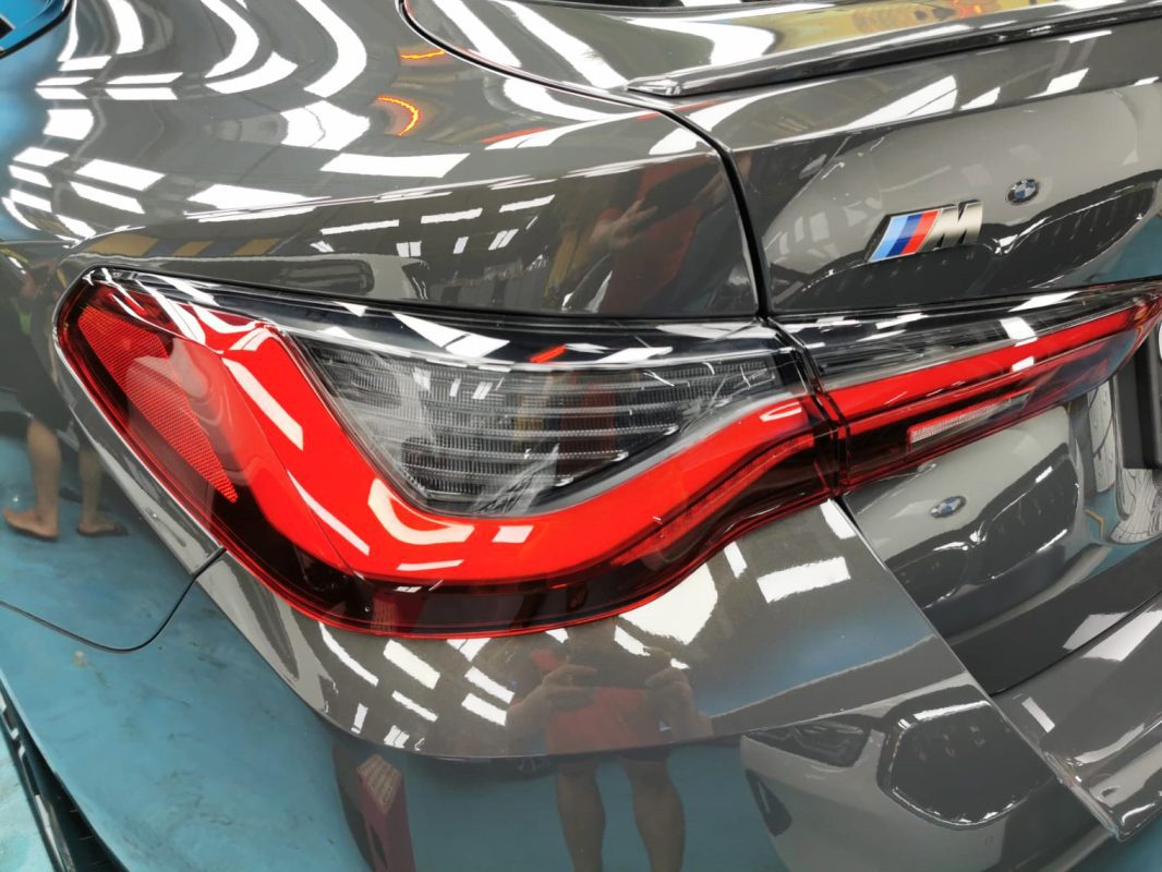 The coated bonnet of the BMW 4 Series under workshop lighting.