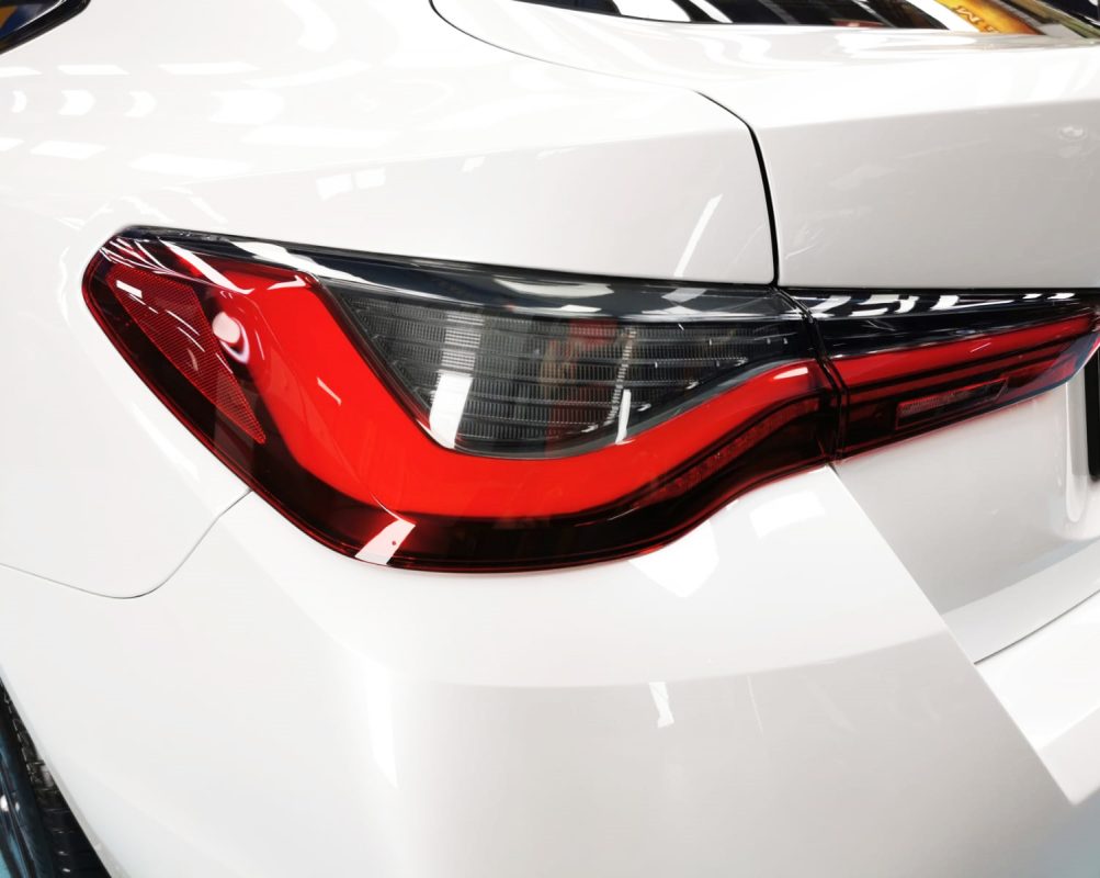 The coated bonnet of the BMW 420i under workshop lighting.