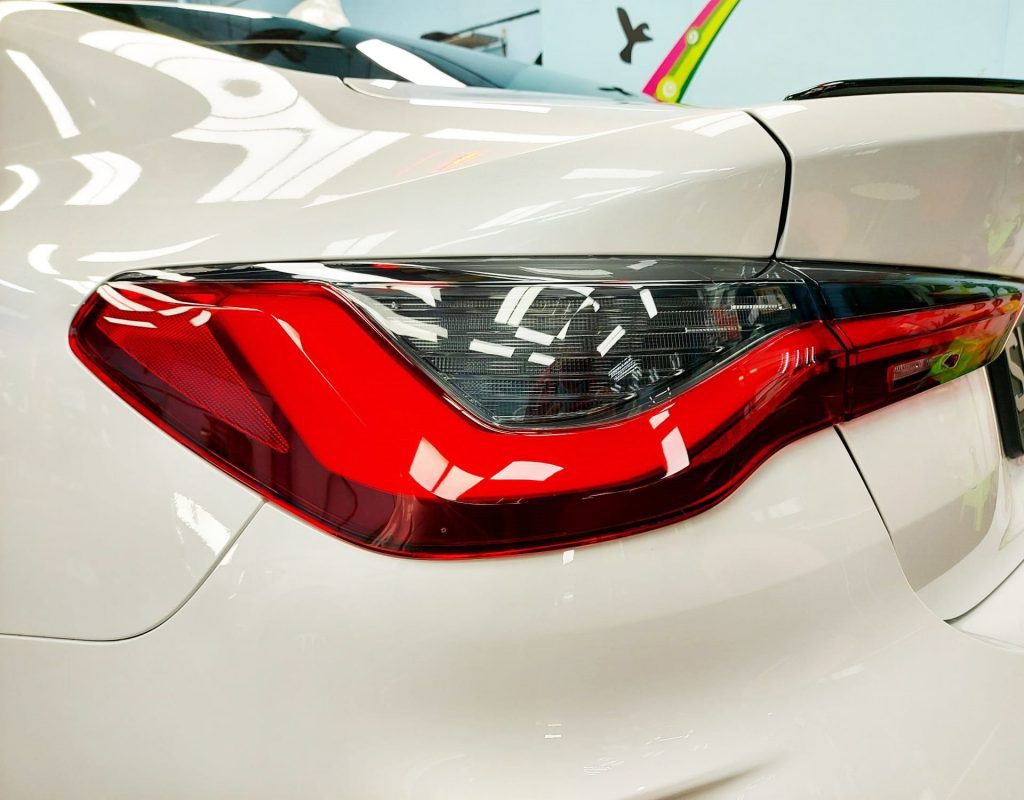 The coated bonnet of the BMW 430i under workshop lighting.