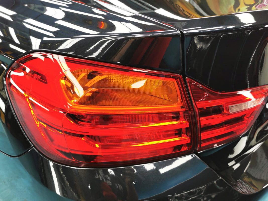 The coated bonnet of the BMW 435i Coupe under workshop lighting.