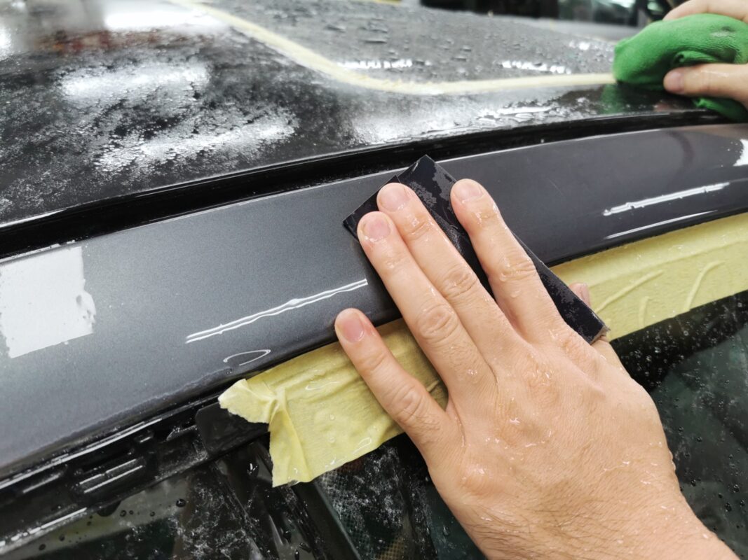 Wet-sanding the BMW 435i on Day 4 to achieve a smooth, level surface.