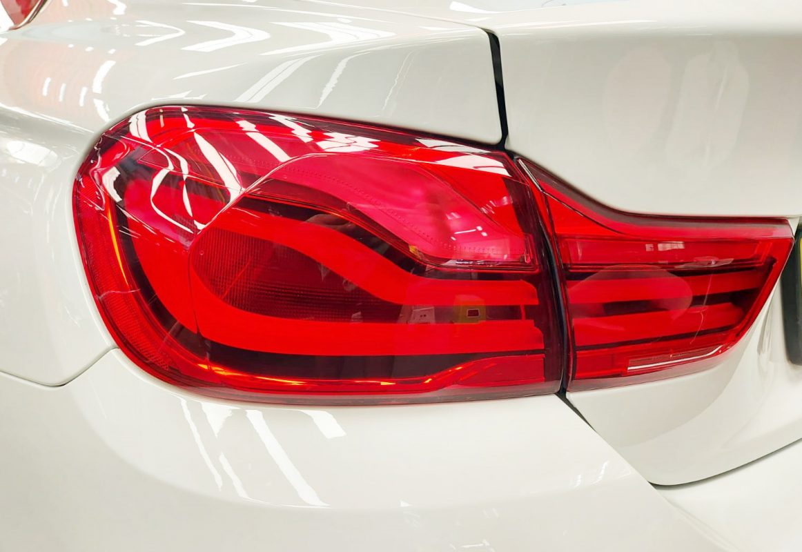 The coated bonnet of the BMW 440i under workshop lighting.