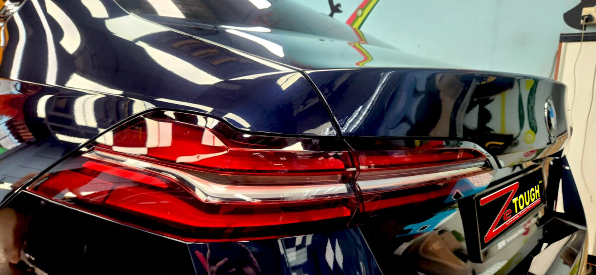The coated bonnet of the BMW 5 Series under workshop lighting.