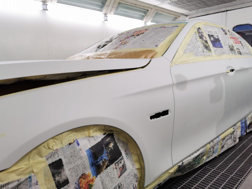 Non-painted surfaces being masked off on the 5 Series before spraying.