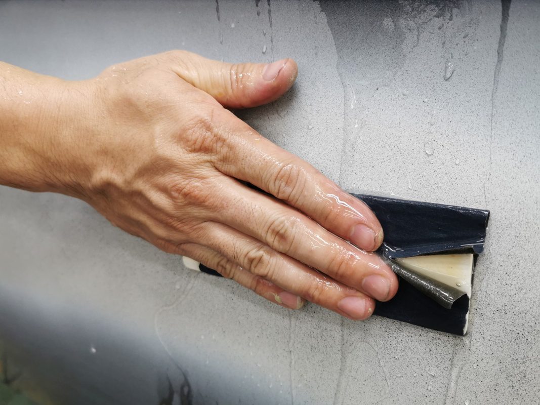 Wet-sanding the 5 Series's panels to smooth the surface.