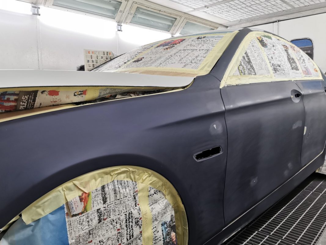Non-painted surfaces being masked off on the 5 Series before spraying.