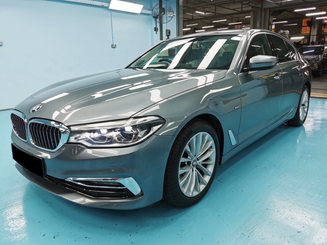 The BMW 5 Series as it arrived, showing deep scratches and paint damage on the front.