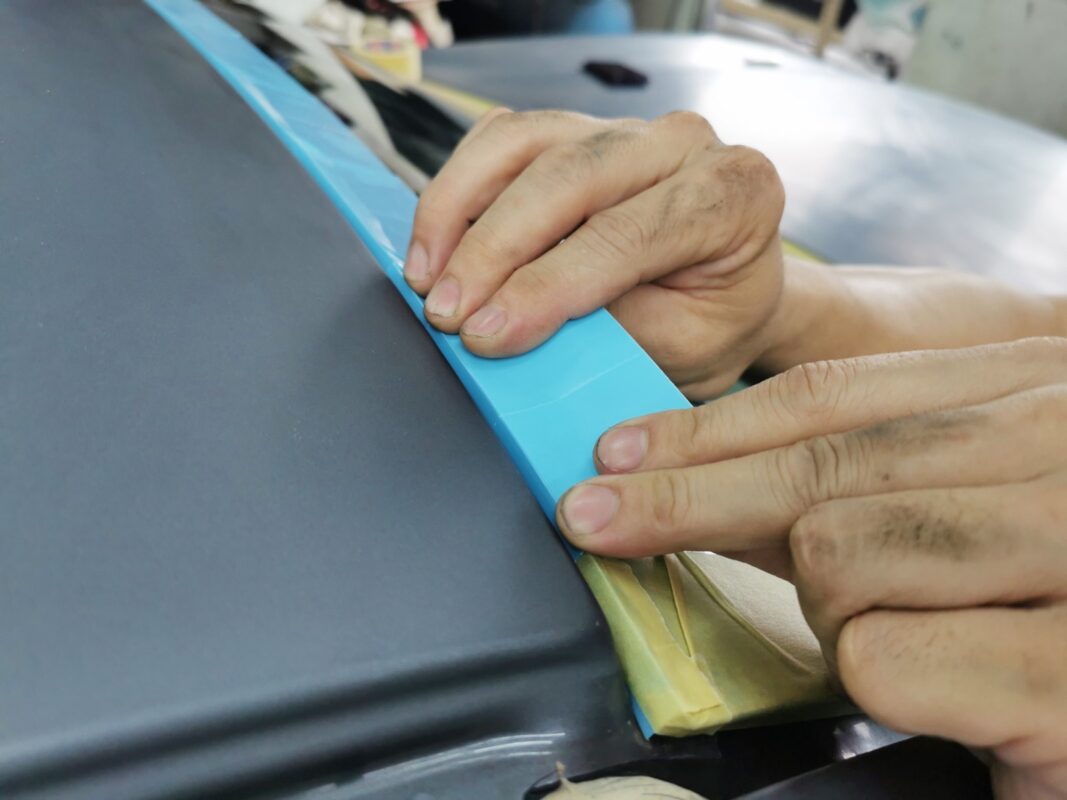 The BMW 5 Series masked and surface-prepped ahead of the spray booth.
