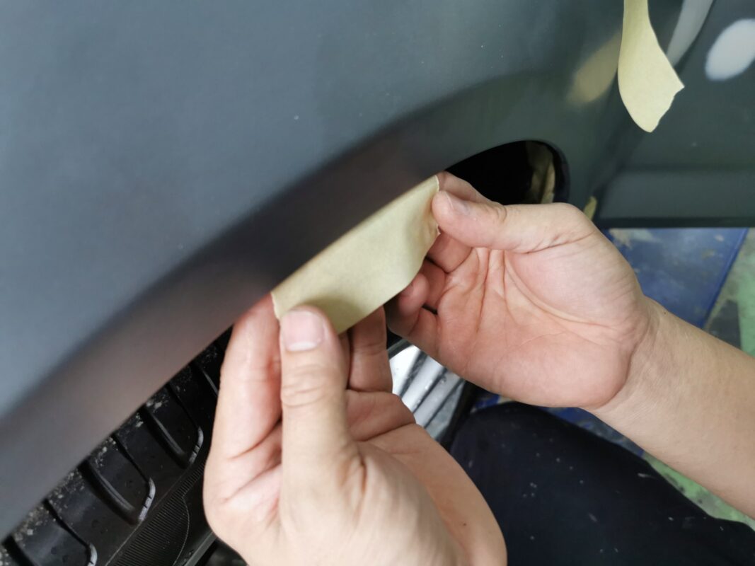 Careful masking applied to the BMW 5 Series to protect unsprayed areas.