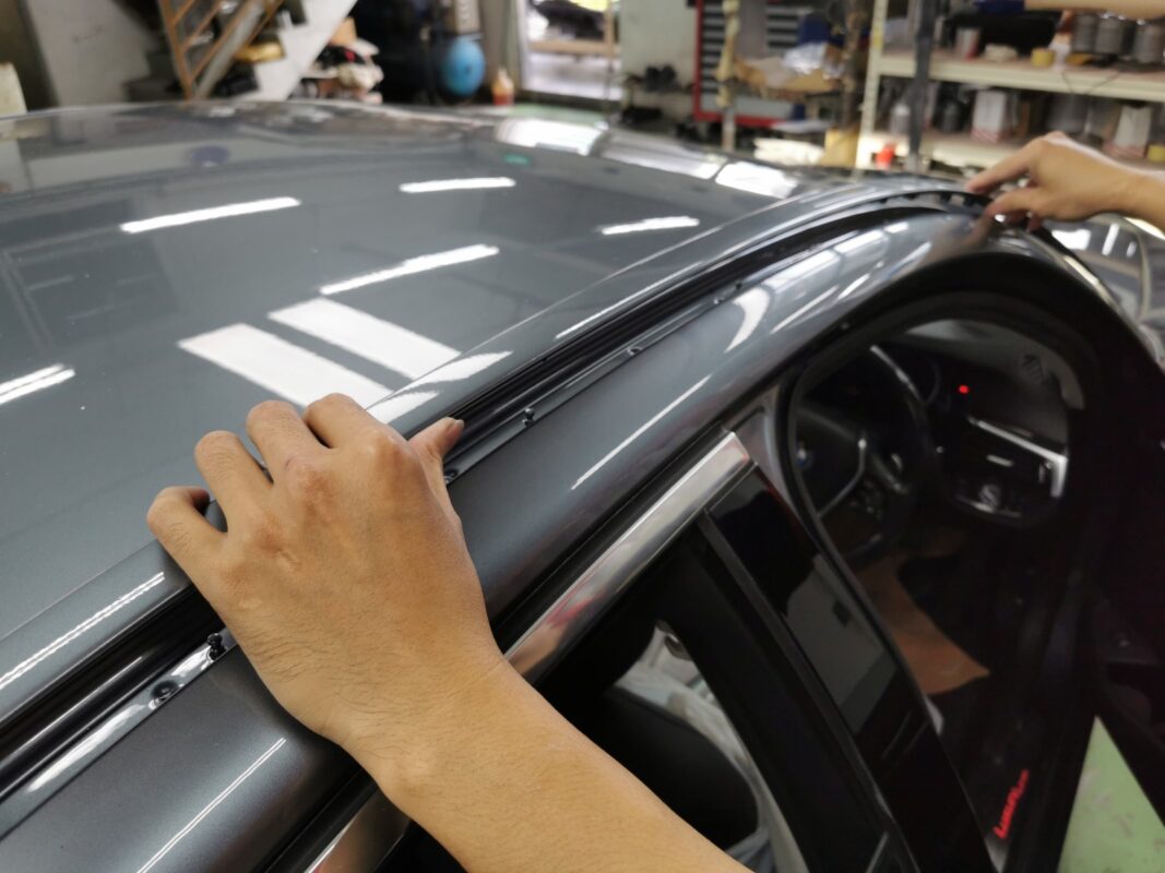 Reassembly of the BMW 5 Series after painting, parts being refitted carefully.