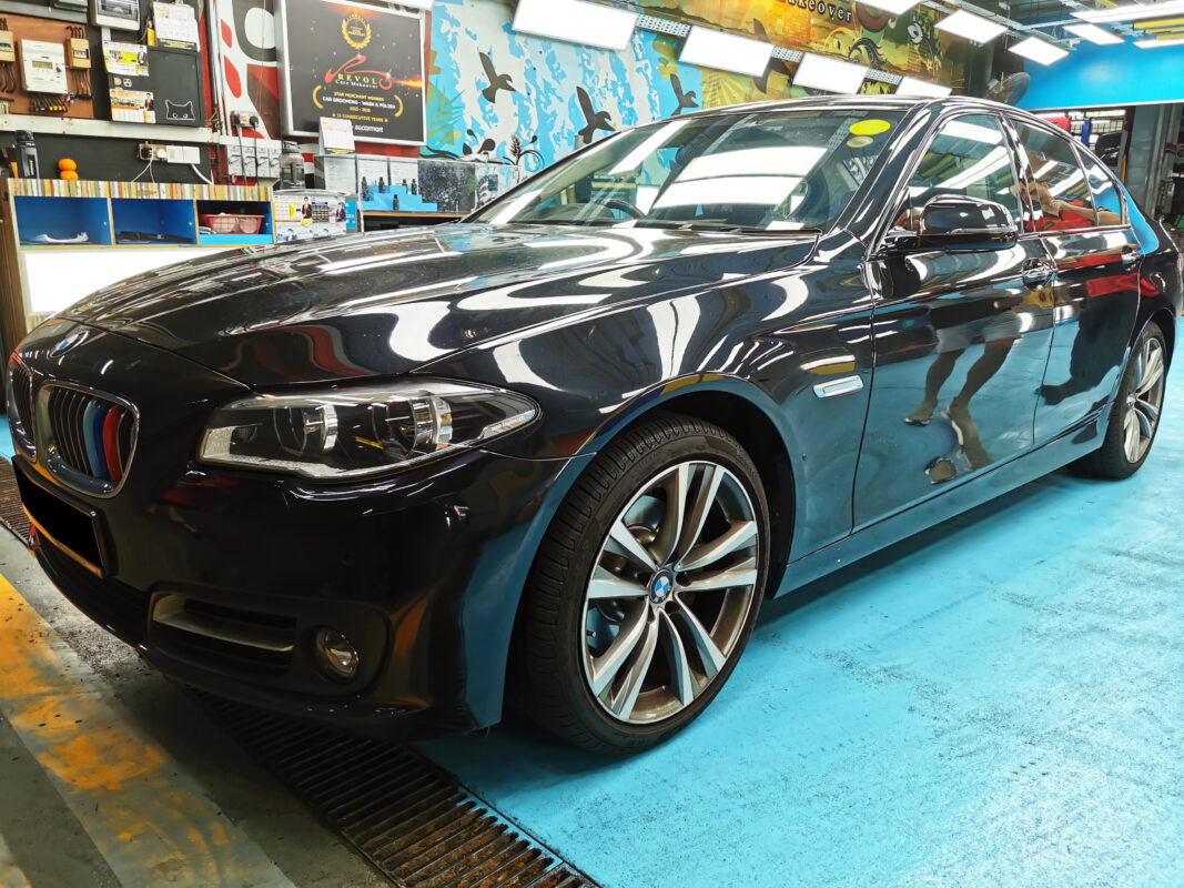 The BMW 5 Series as it arrived at Revol Carz, front three-quarter view showing dull paintwork.