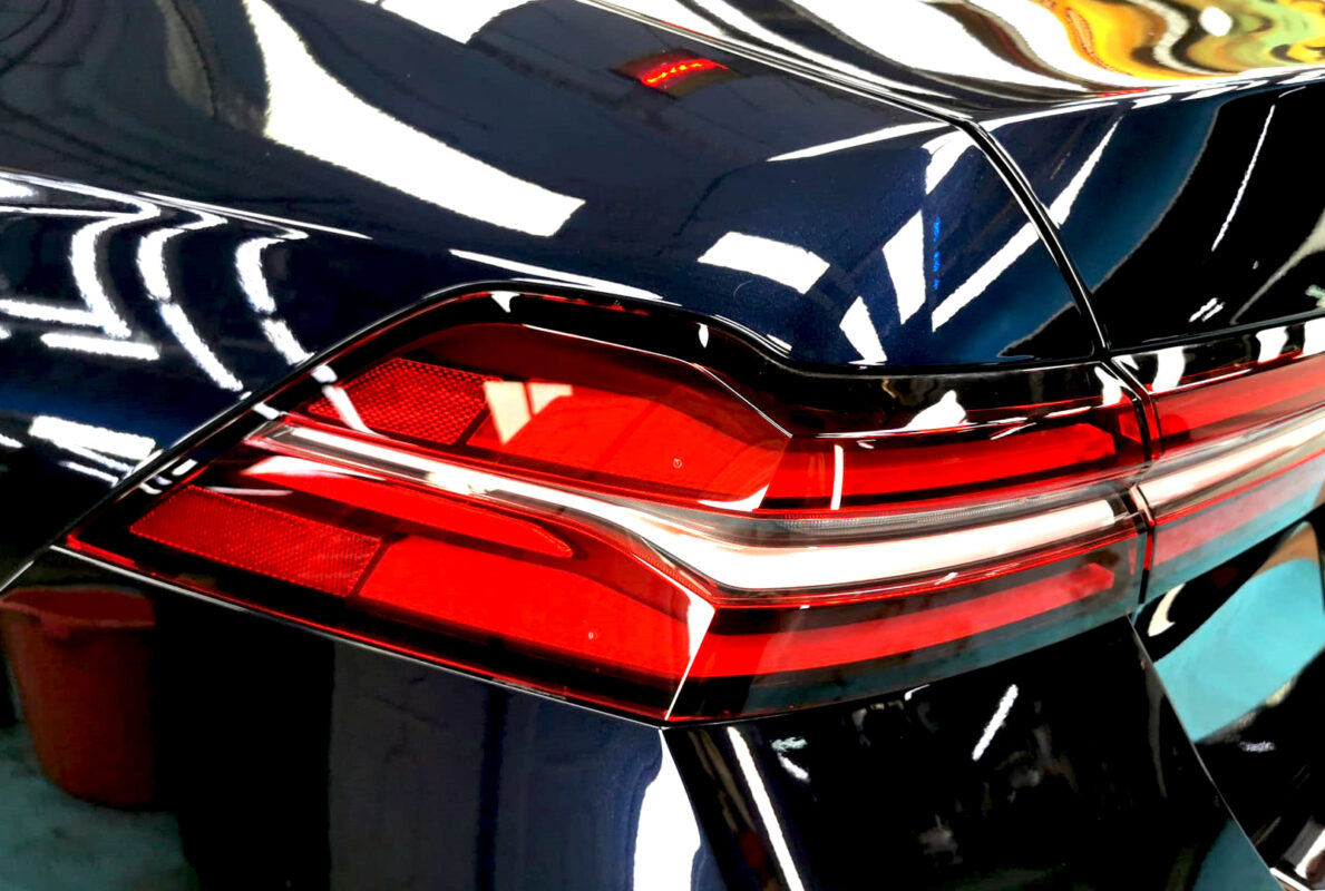 The coated bonnet of the BMW 5 Series under workshop lighting.