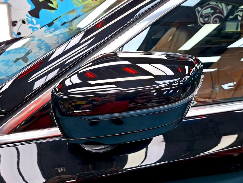 Black wing mirror on the 5 Series with ceiling lights reflected.
