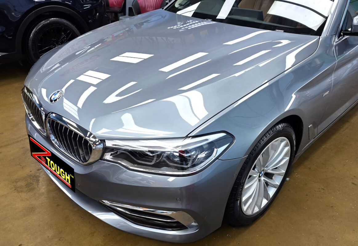 The BMW 5 Series's coated paintwork under workshop lighting.