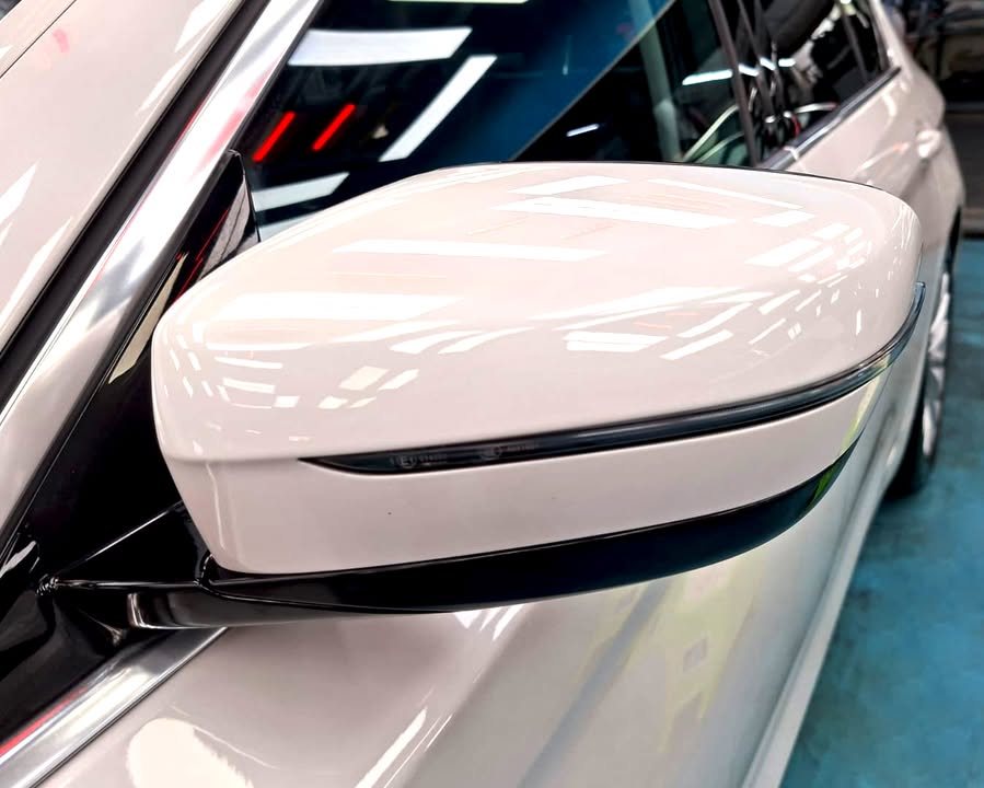 White side mirror cap on the 5 Series reflecting the ceiling lights.