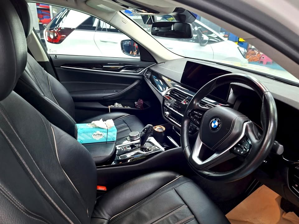 Black leather seats and steering wheel inside the BMW 5 Series.