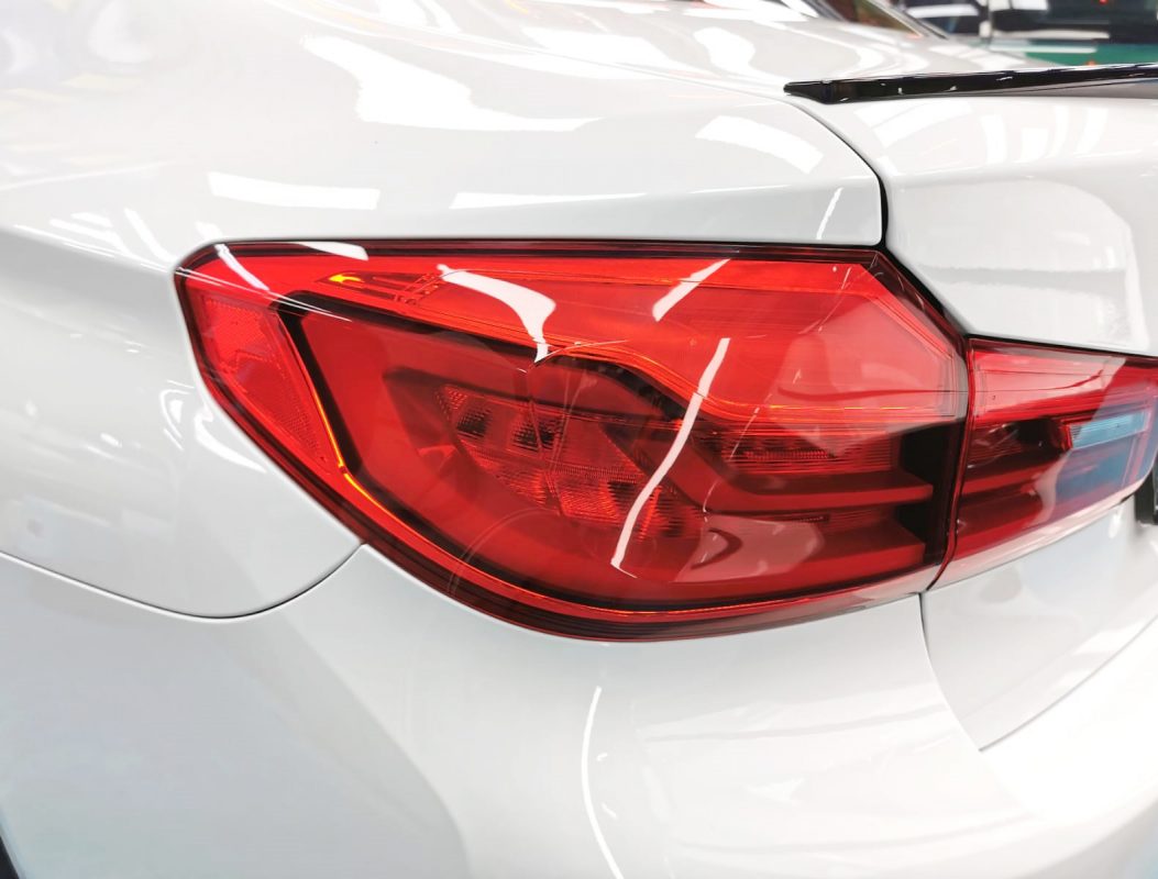 The coated bonnet of the BMW 520d under workshop lighting.