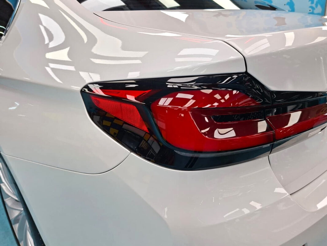 The coated bonnet of the BMW 520i under workshop lighting.