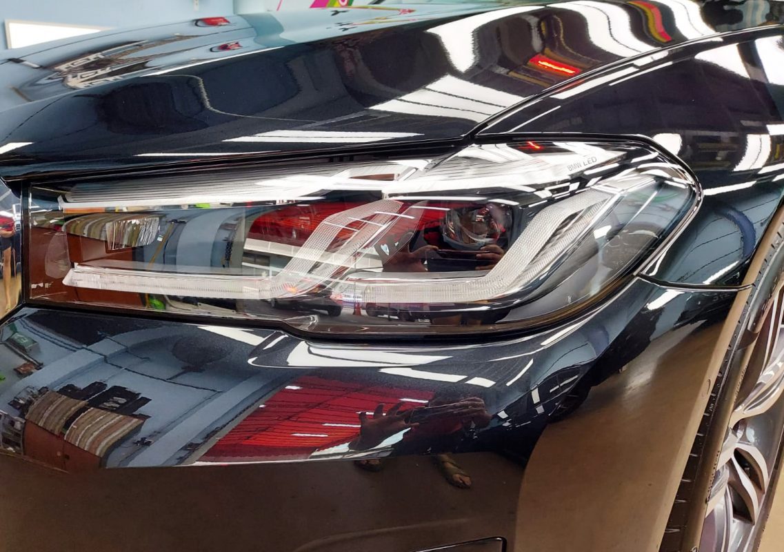 The 520i's coated paintwork showing clean reflections.