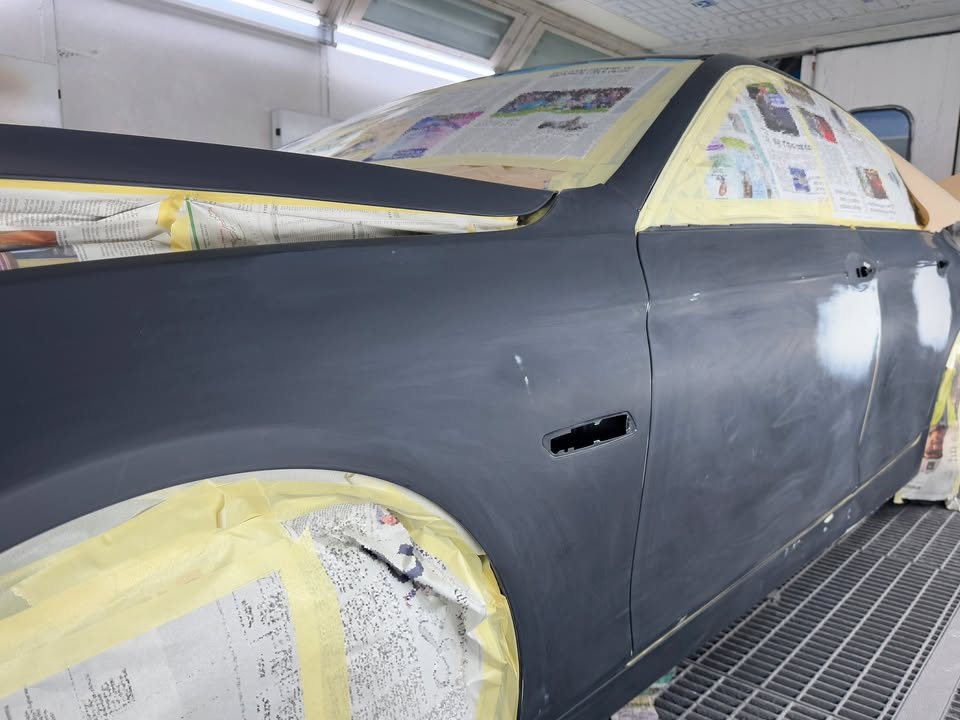 The BMW masked with tape and newspaper in the spray booth, body in primer.
