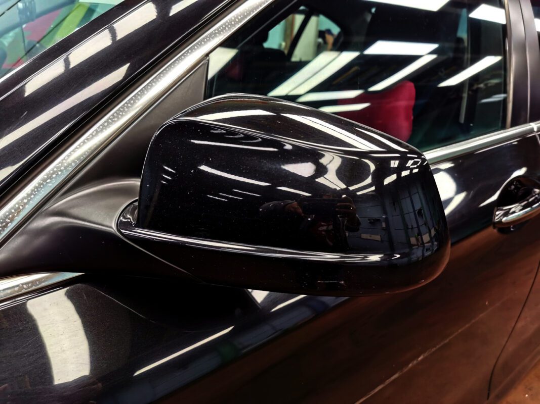 Close-up of scratches and blemishes on a panel of the BMW 520i before repairs.