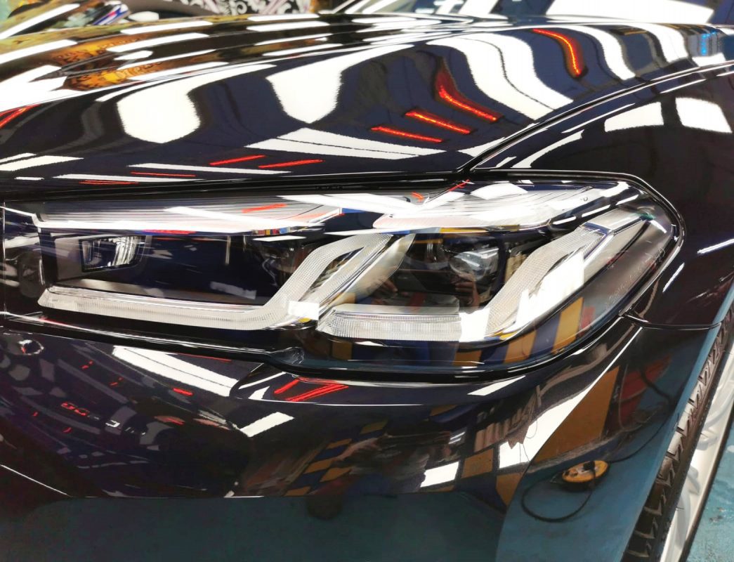 The 520i's coated paintwork showing clean reflections.