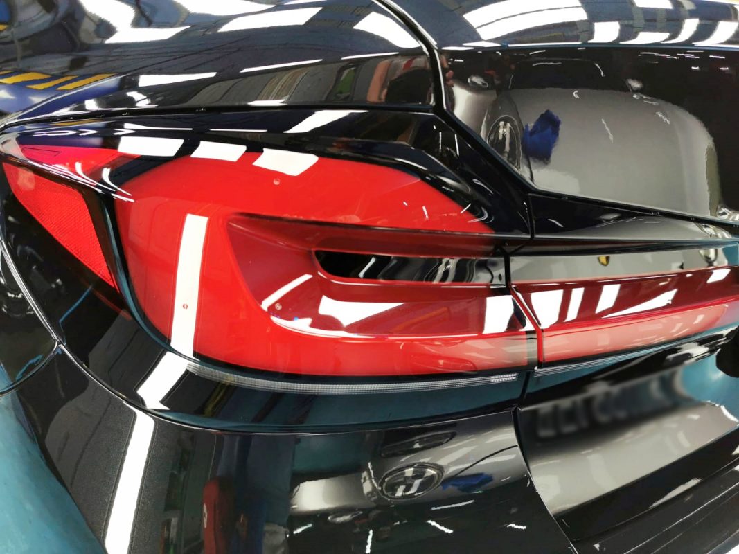 The coated bonnet of the BMW 520i under workshop lighting.