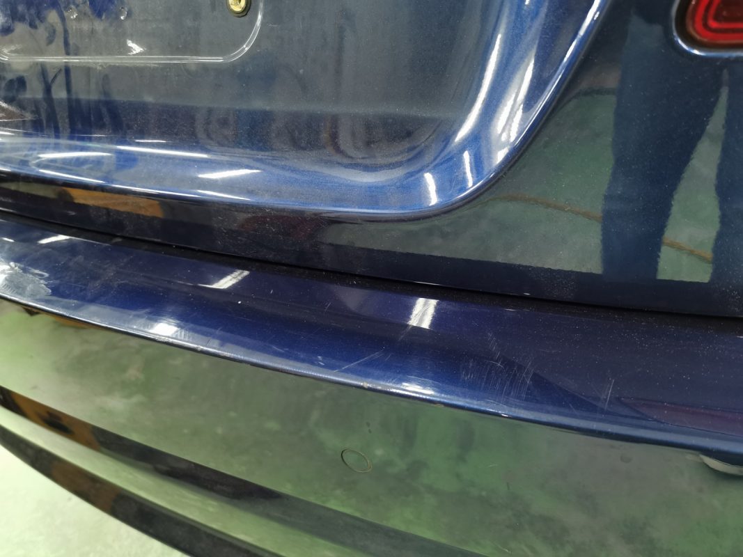 The BMW 523i at intake, showing deep scratches on the body.
