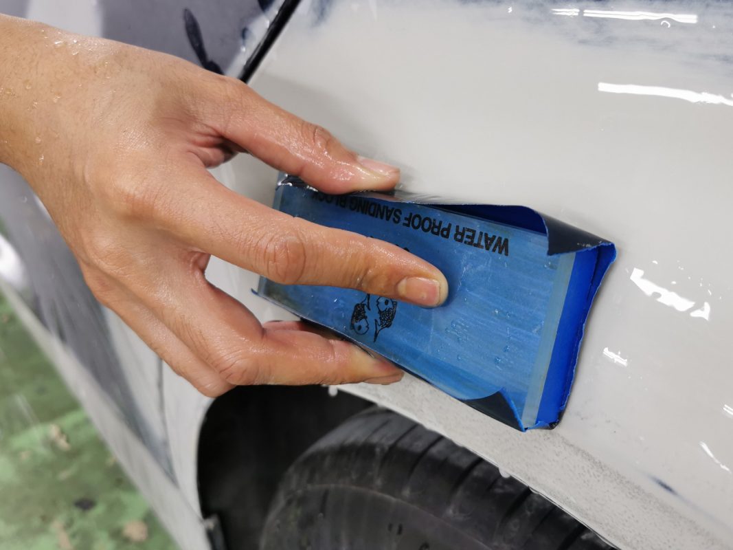 Continuing to wet-sand the body in preparation for spraying.