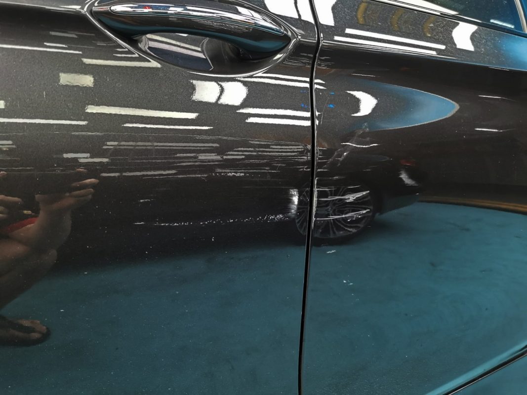 Close-up of the BMW 528i's bodywork showing paint damage before the respray.