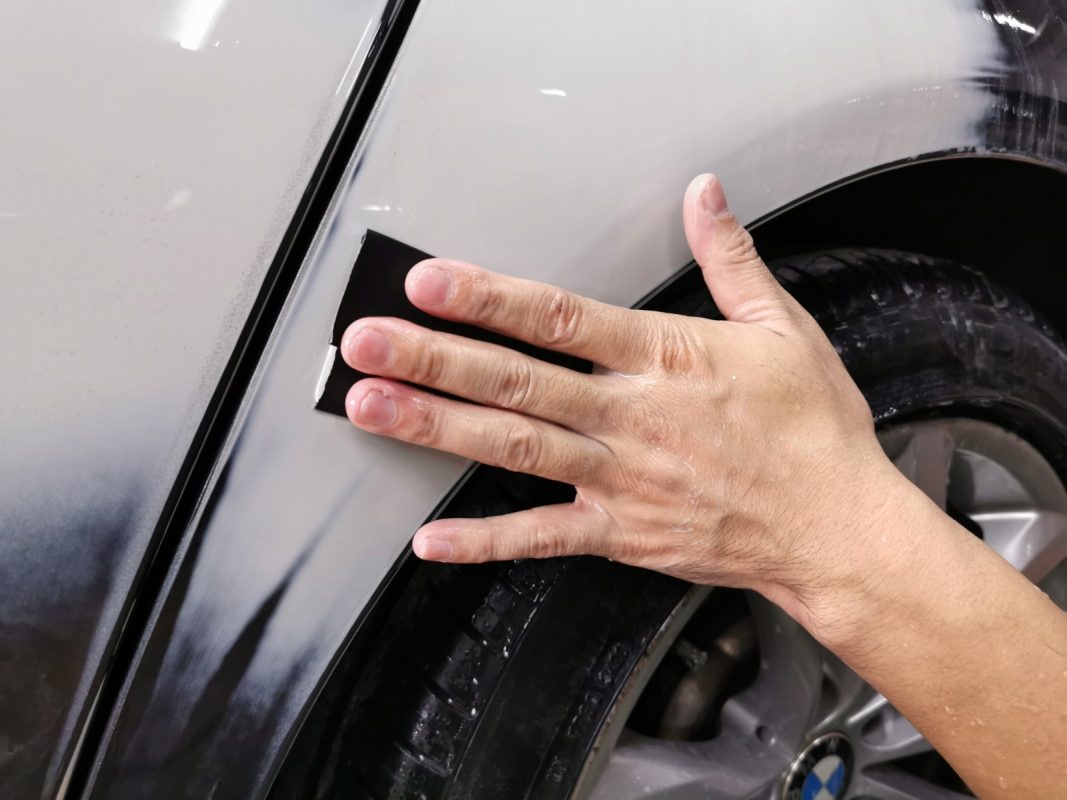 Wet-sanding the BMW 528i to create a smooth, level foundation for the new paint.