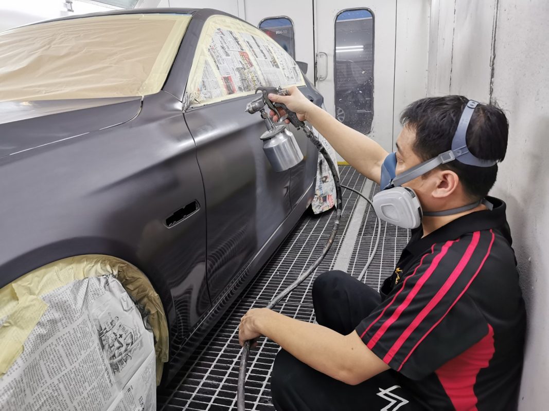 BMW 528i in the spray booth at Revol Carz, fresh coat of paint being applied.