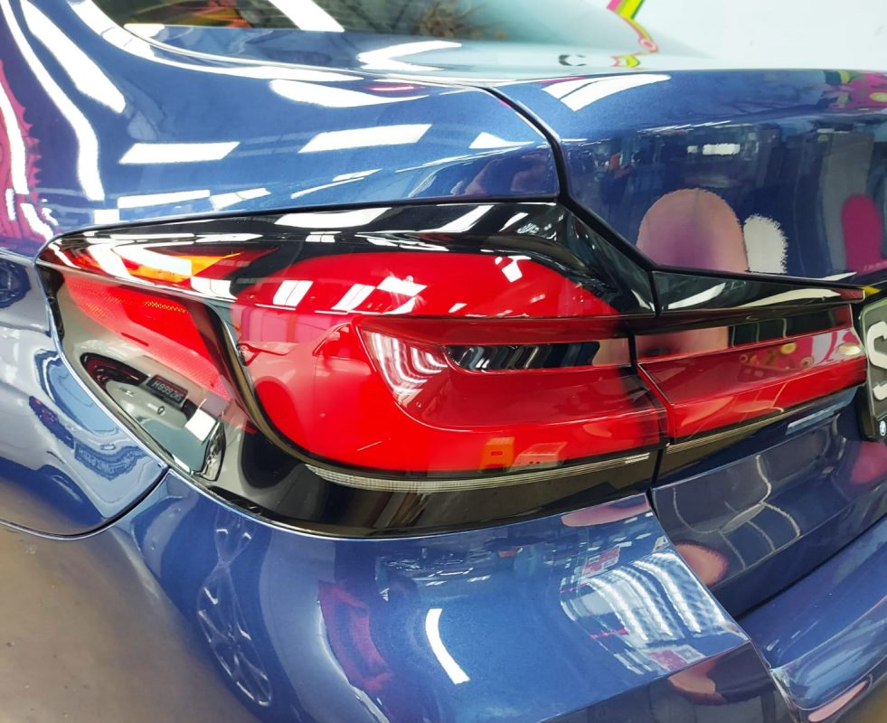 Coated bonnet of the BMW 530i under workshop lighting.