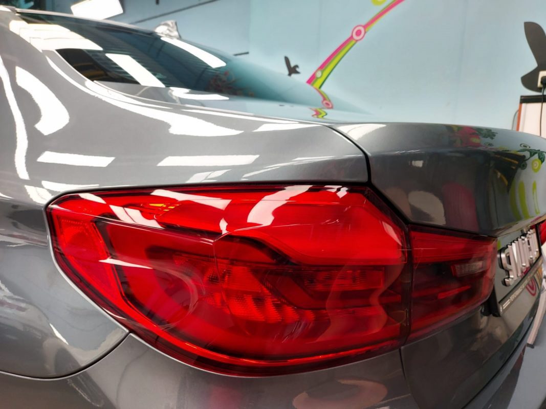 The coated bonnet of the BMW 540i under workshop lighting.
