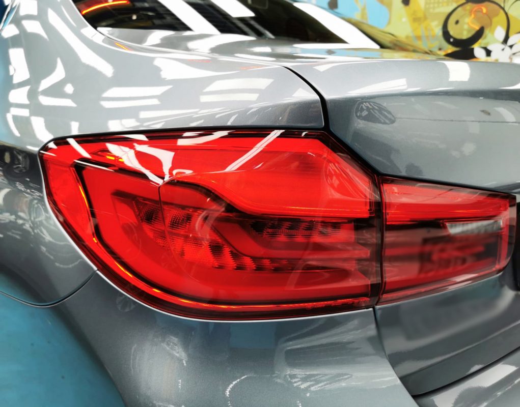 The coated bonnet of the BMW 540i under workshop lighting.