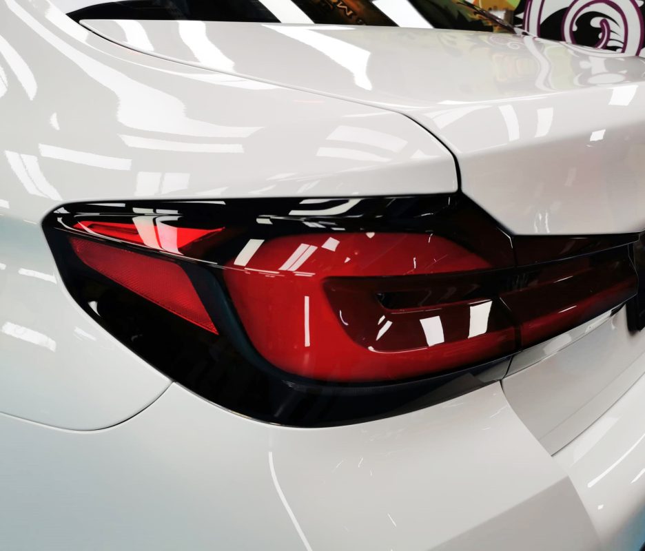 The coated bonnet of the BMW 5 Series under workshop lighting.
