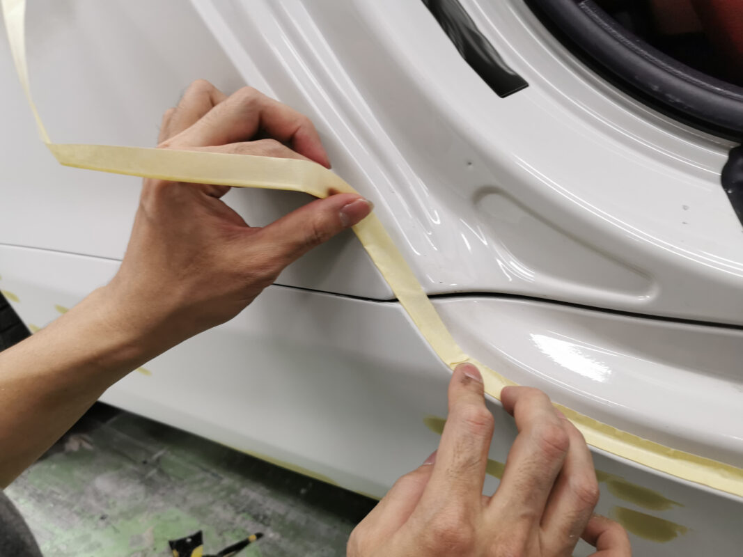 Detailed masking on the BMW 6 Series, protecting trim and glass from paint.