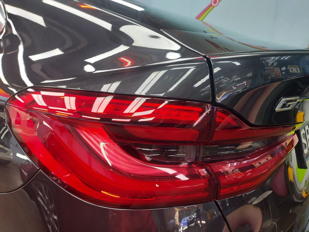 The coated bonnet of the BMW 6 Series under workshop lighting.