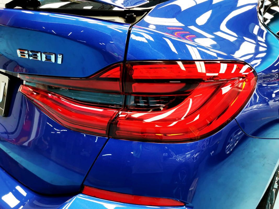 The coated bonnet of the BMW 630i under workshop lighting.